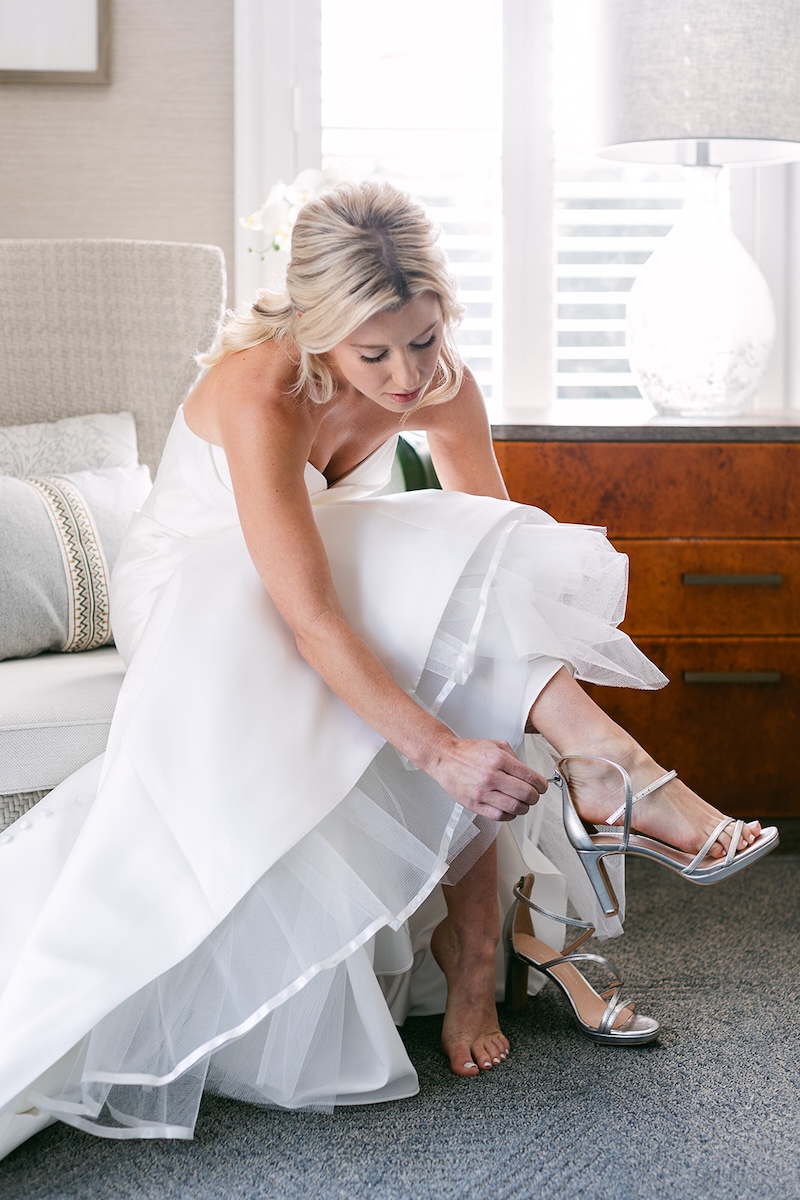 Bride puts on silver bridal heels on wedding day. Elegant wedding at the Ritz-Carlton Lake Oconee in Georgia. Sarah Bradshaw Photography.