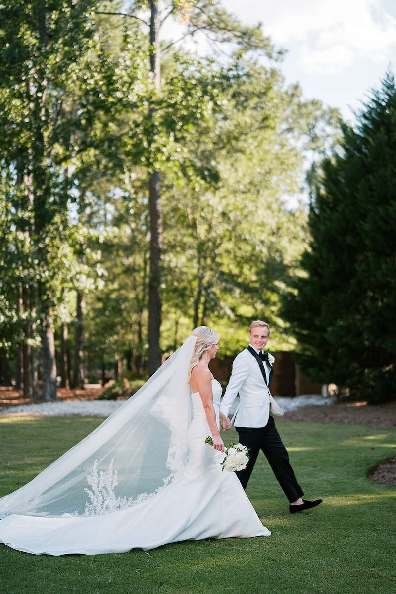 Candid portrait of bride and groom walking. Elegant wedding at the Ritz-Carlton Lake Oconee in Georgia. Sarah Bradshaw Photography.