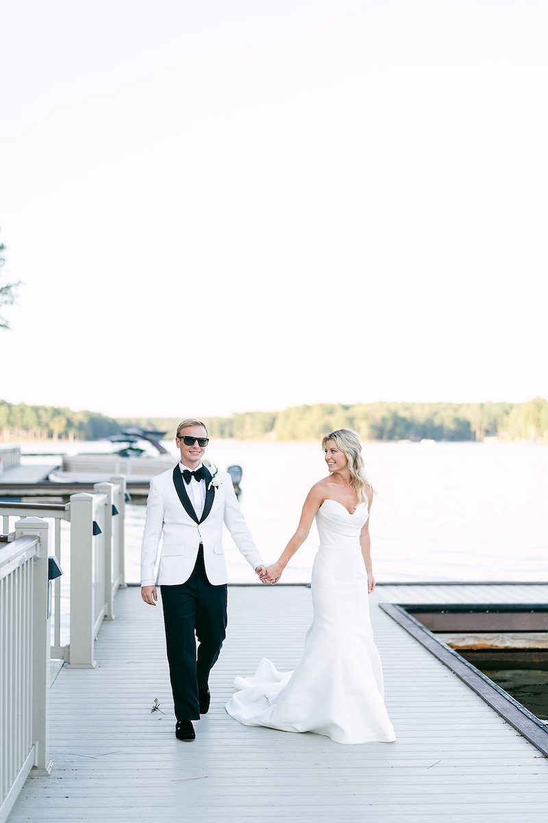 Bride and groom walk on lakeside dock. Elegant wedding at the Ritz-Carlton Lake Oconee in Georgia. Sarah Bradshaw Photography.