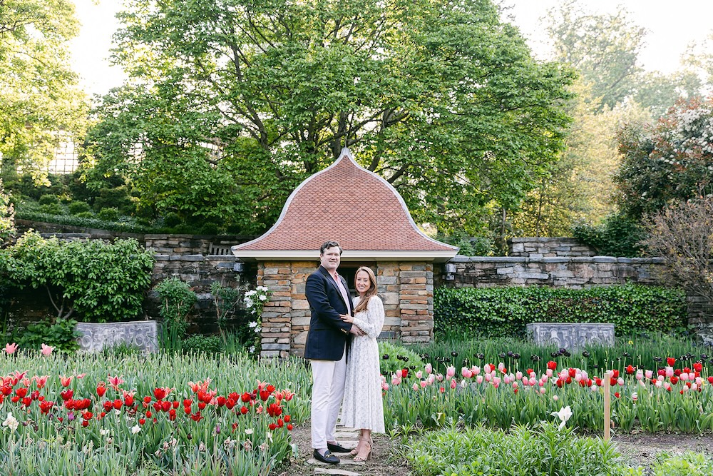 Couple poses in tulip garden. Spring wedding engagement photo session. Sarah Bradshaw Photography.