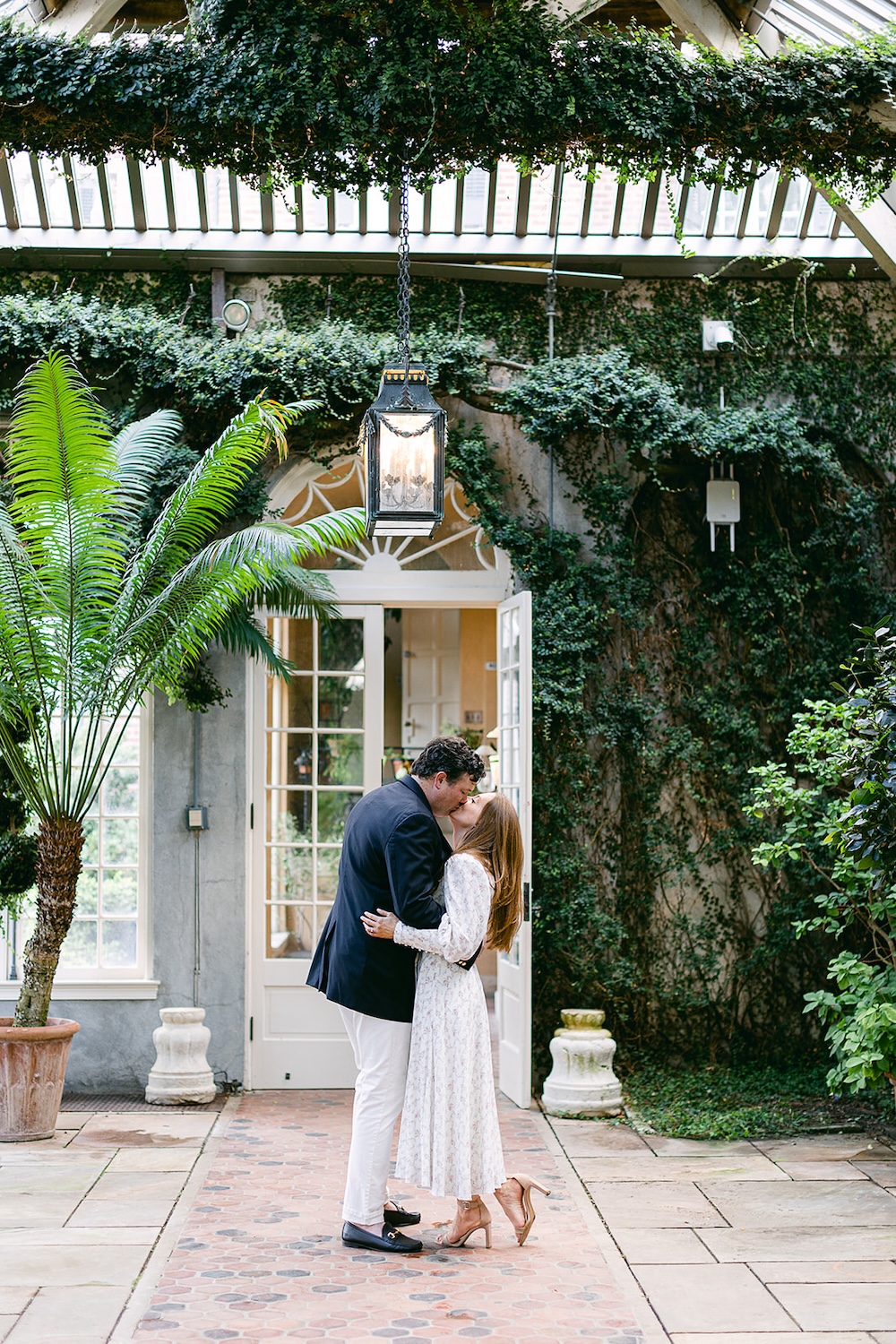 couple kisses under greenery canopy. Spring wedding engagement photo session. Sarah Bradshaw Photography.