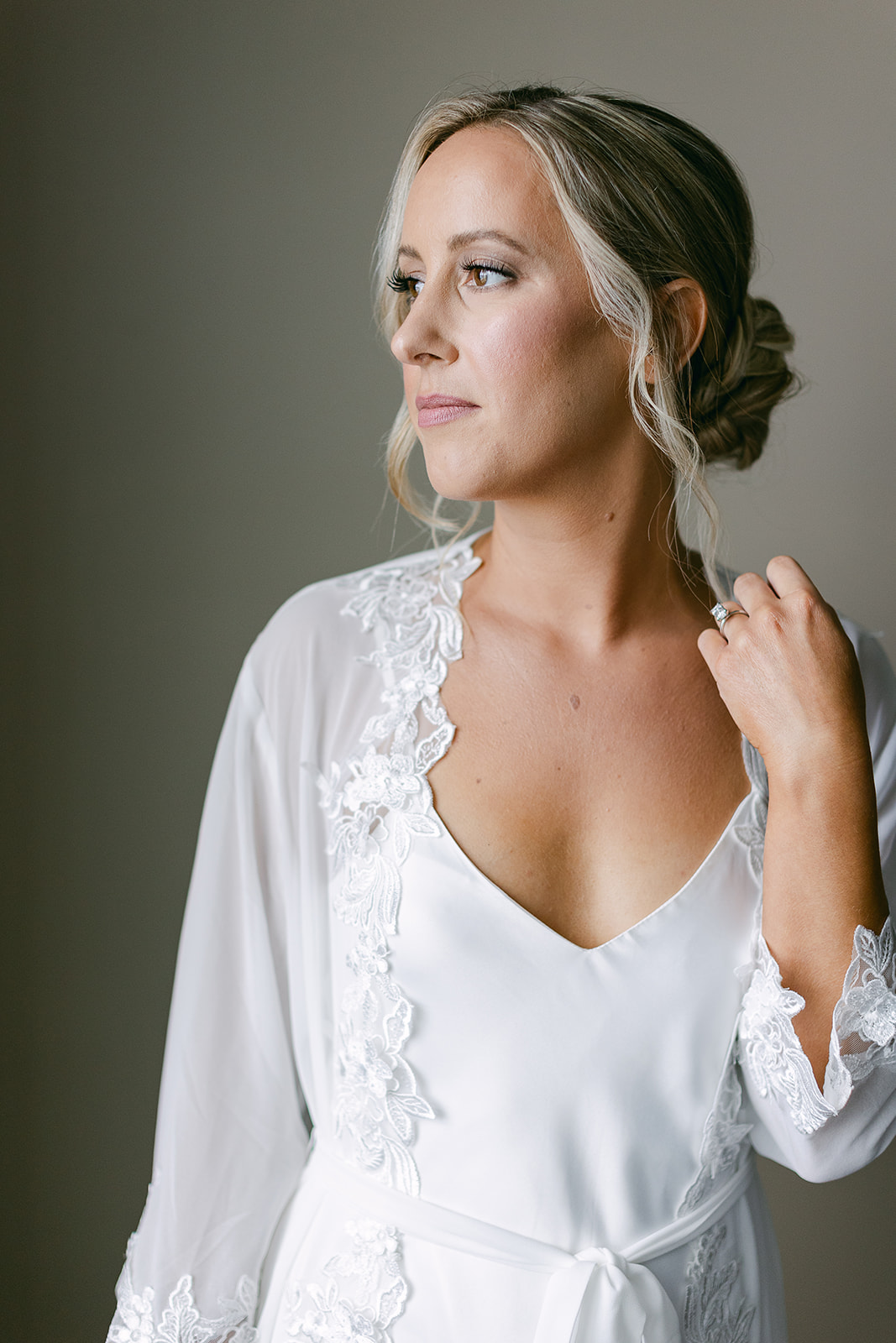 Bride with wedding day hair and makeup done in lace bridal robe. high end elopement wedding in tampa florida. sarah bradshaw photography.