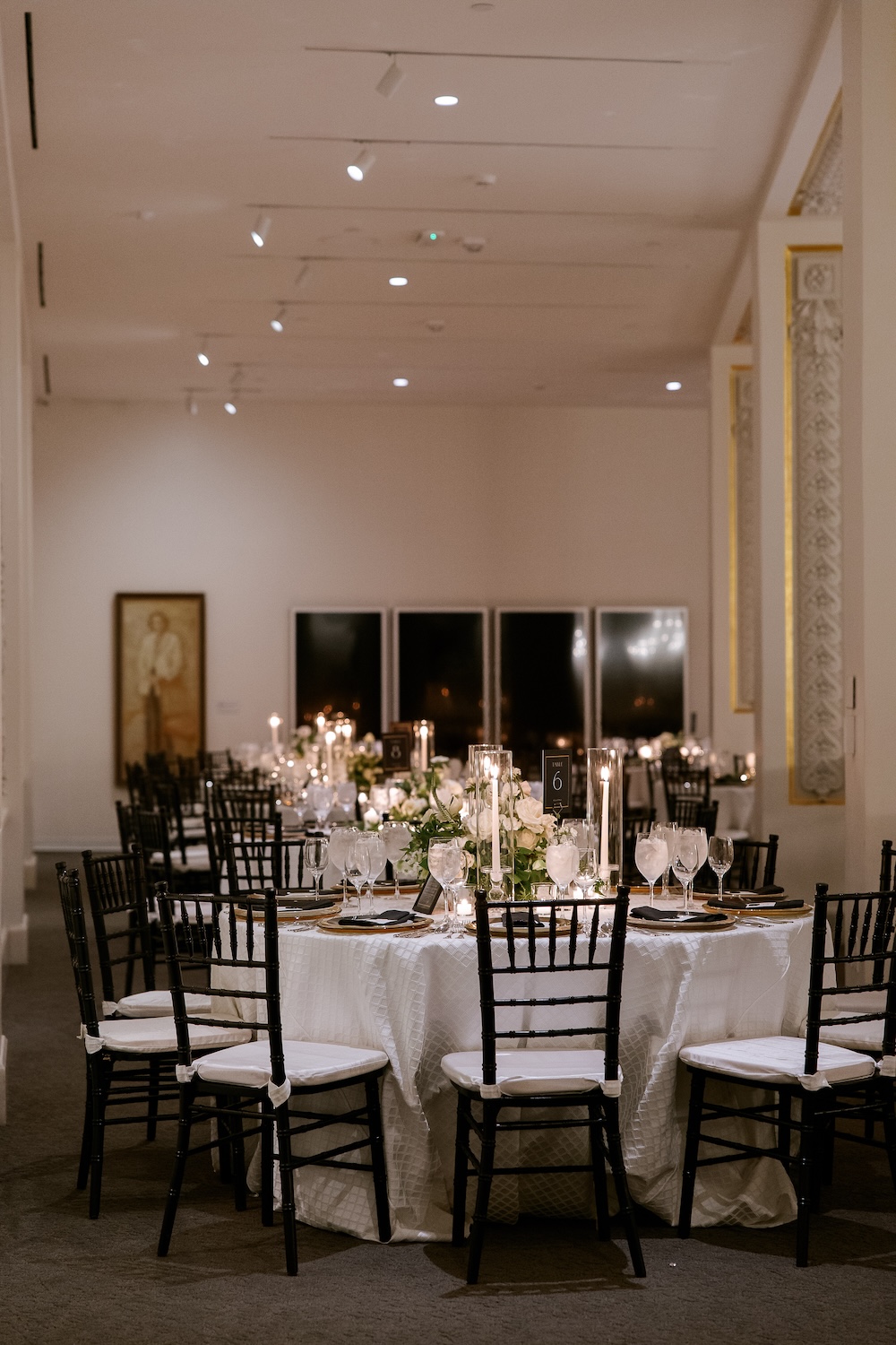 Round wedding reception tables with candles and low floral centerpieces. Modern Washington DC wedding at National Museum of Women in the Arts. Sarah Bradshaw Photography.