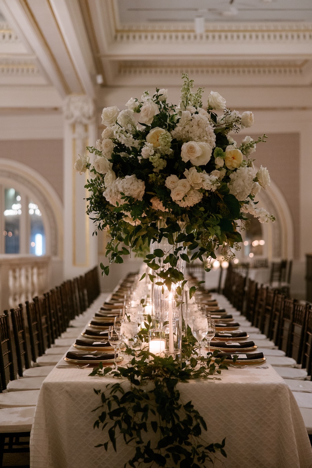 Long wedding reception table with candles and tall floral arrangements. Modern Washington DC wedding at National Museum of Women in the Arts. Sarah Bradshaw Photography.