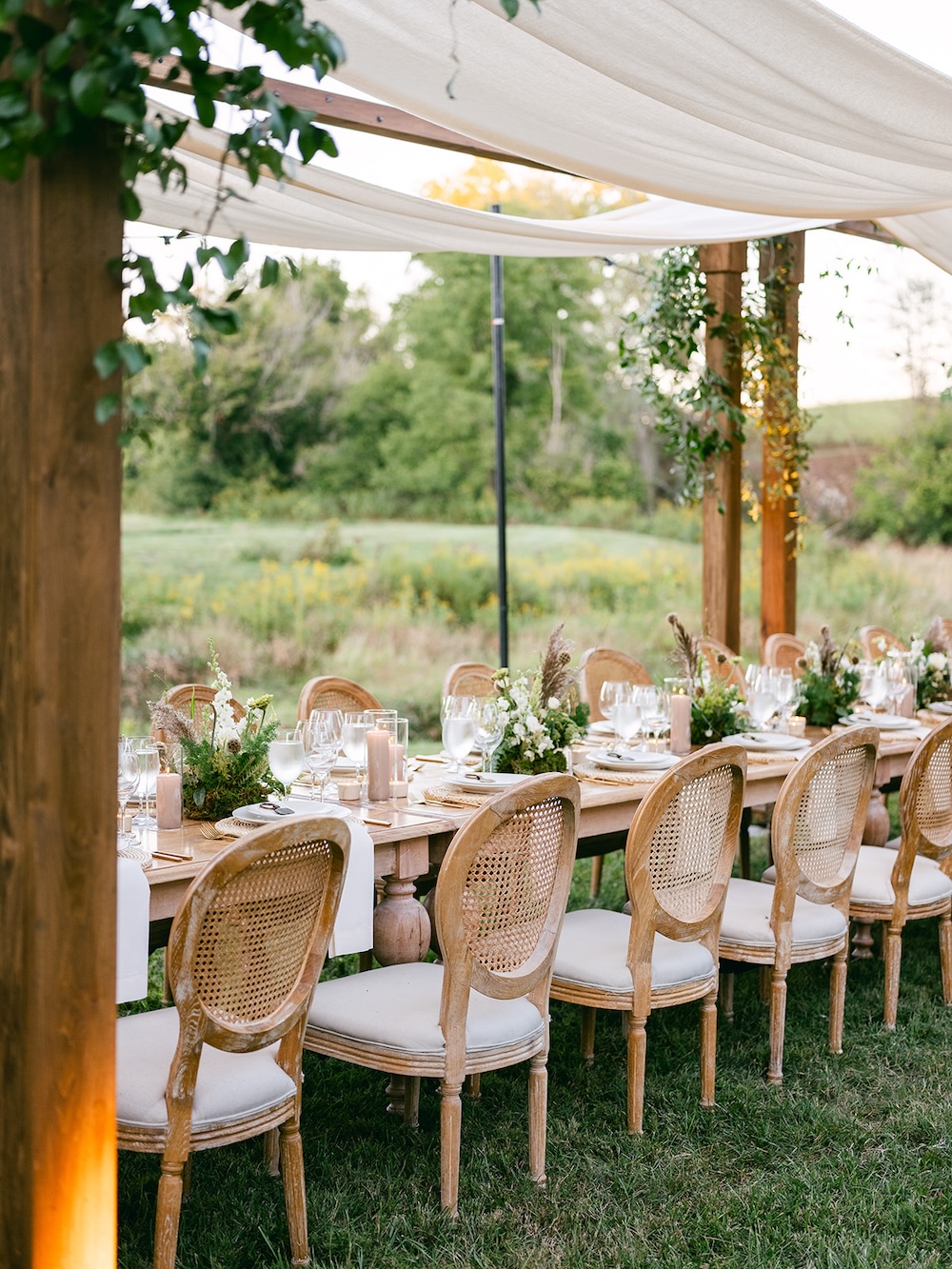 Boho chic table design, rattan chairs, farmhouse style tables, small centerpieces. Milestone birthday party celebration weekend in Middleburg, Virginia. Sarah Bradshaw Photography.