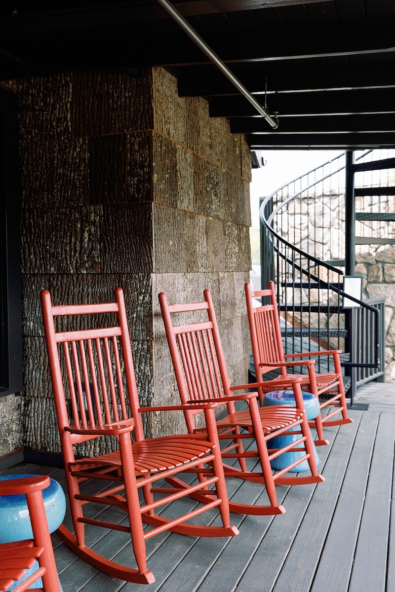 Red rocking chairs on rustic porch. High Hampton in North Carolina, Sarah Bradshaw Photography