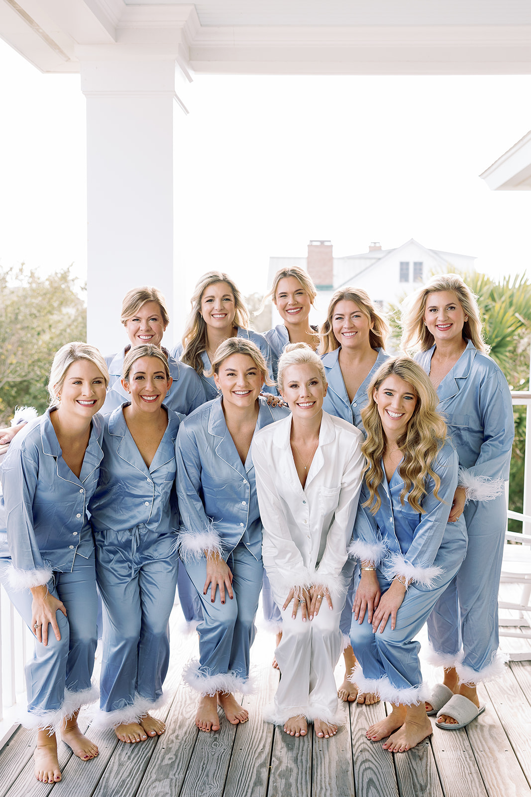 bride poses with bridesmaids in matching pajamas on wedding morning. Classic Black Tie wedding in Georgetown, SC. Sarah Bradshaw Photography