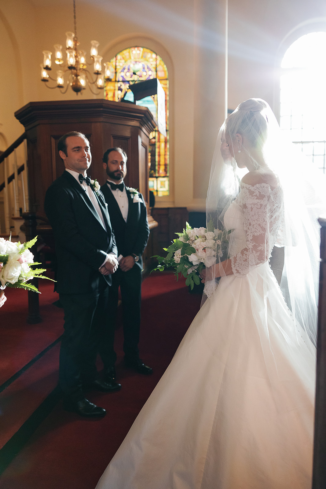 Bride meets groom at alter in chapel, sunlight streaming in. Classic Black Tie wedding in Georgetown, SC. Sarah Bradshaw Photography