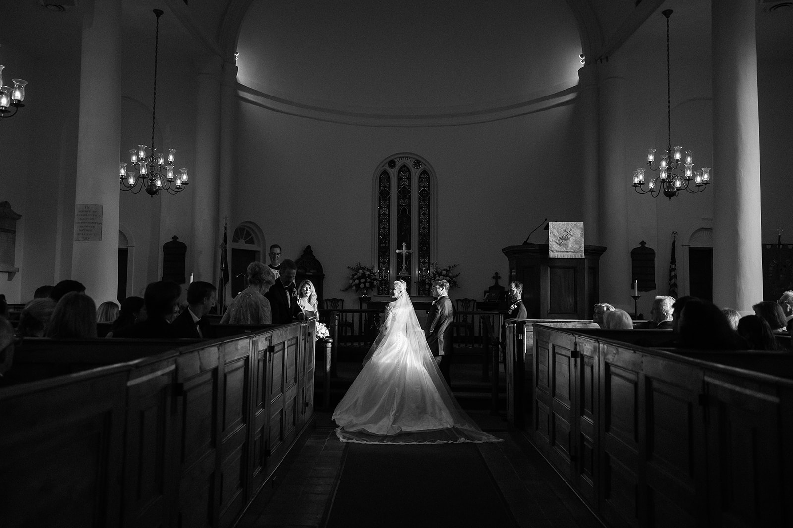 black and white photo of bride and groom at altar, wedding ceremony chapel. Classic Black Tie wedding in Georgetown, SC. Sarah Bradshaw Photography