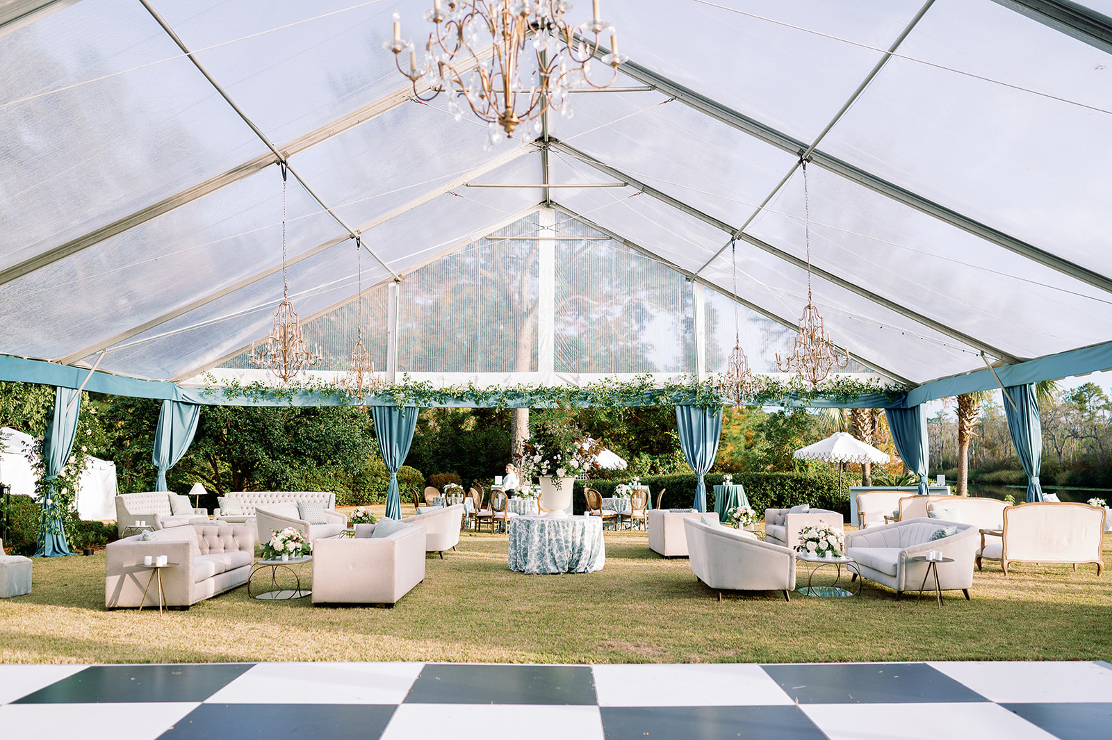 Clear wedding tent reception, white and black checkered dance floor, sofa seating lounges. Classic Black Tie wedding in Georgetown, SC. Sarah Bradshaw Photography