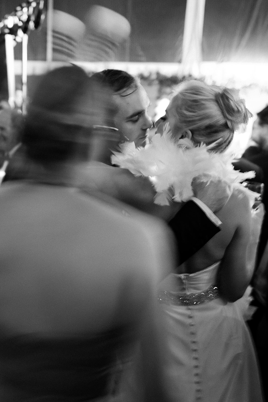 Bride and groom on dance floor kiss, bride wearing feather boa. Classic Black Tie wedding in Georgetown, SC. Sarah Bradshaw Photography