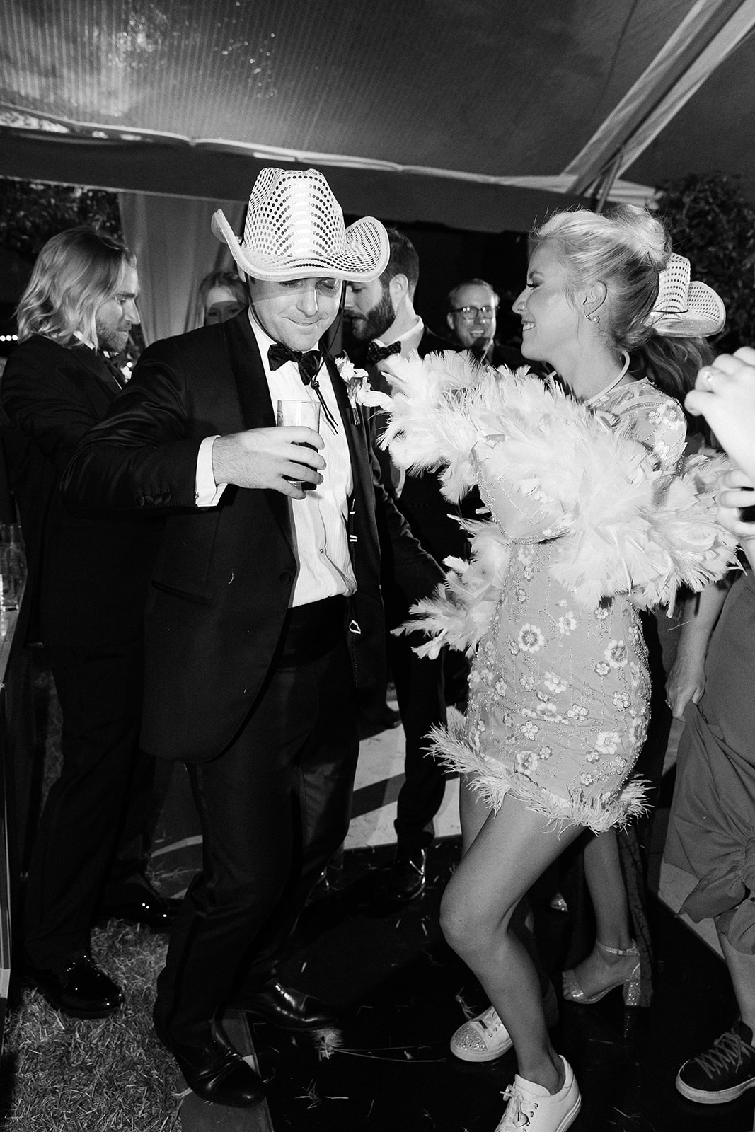 bride in sparkle reception dress dances with feather boa. Classic Black Tie wedding in Georgetown, SC. Sarah Bradshaw Photography