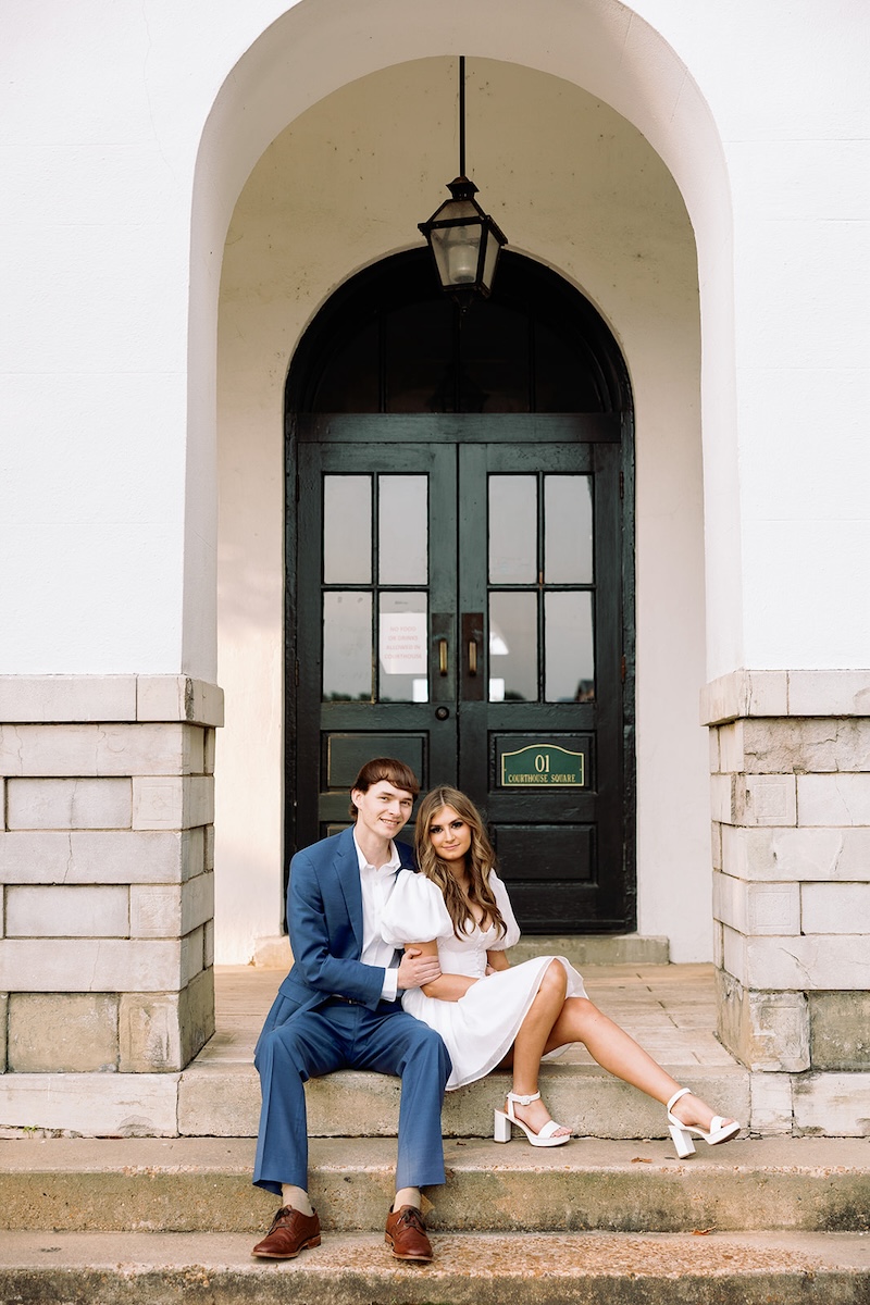 portrait of couple sitting in arch way. southern wedding engagement session, sarah bradshaw photography.