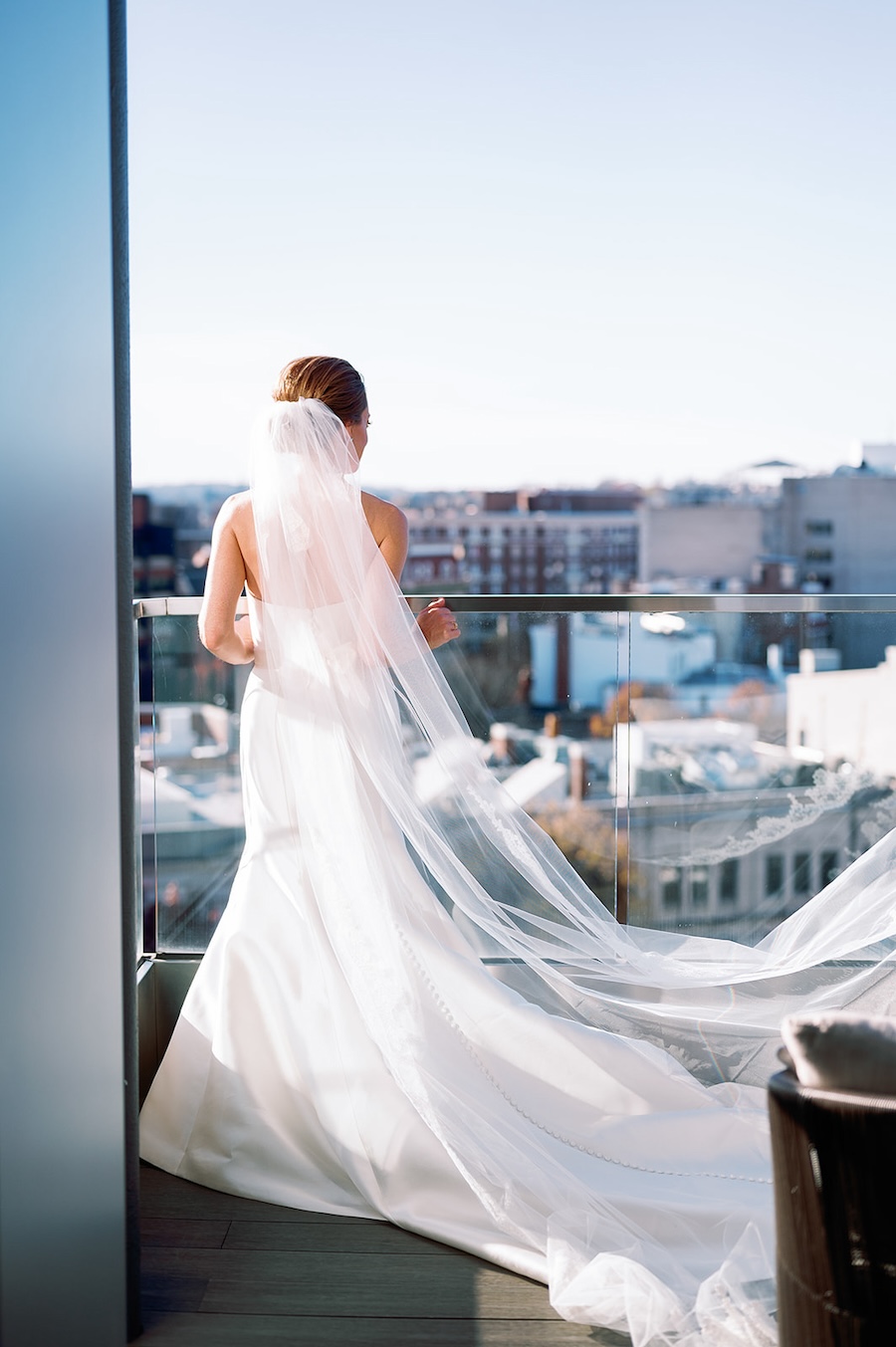 bride on balcony looking over the city, veil blowing in wind. Timeless winter wedding, anderson house, washington dc, sarah bradshaw photography.