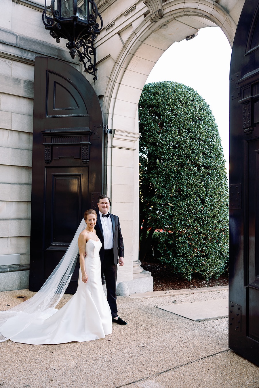 bride and groom portrait at oversized door. Timeless winter wedding, anderson house, washington dc, sarah bradshaw photography.