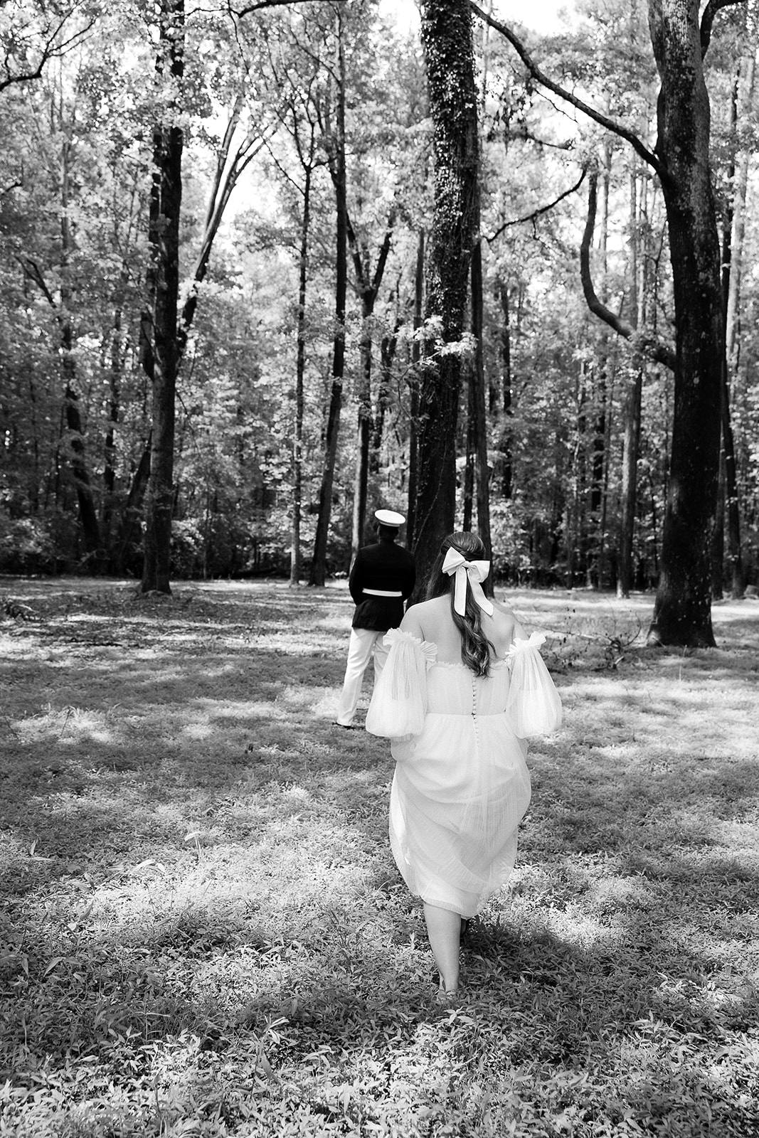 Bride walking in tree grove for first look wedding reveal with groom in military uniform. Private home wedding in South Carolina. Sarah Bradshaw Photography