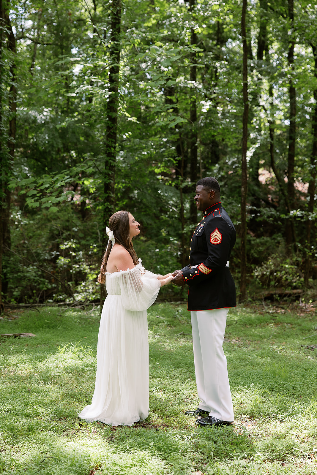 bride in long sleeve dress holds hands with military groom. private home wedding in south carolina. Sarah Bradshaw Photography