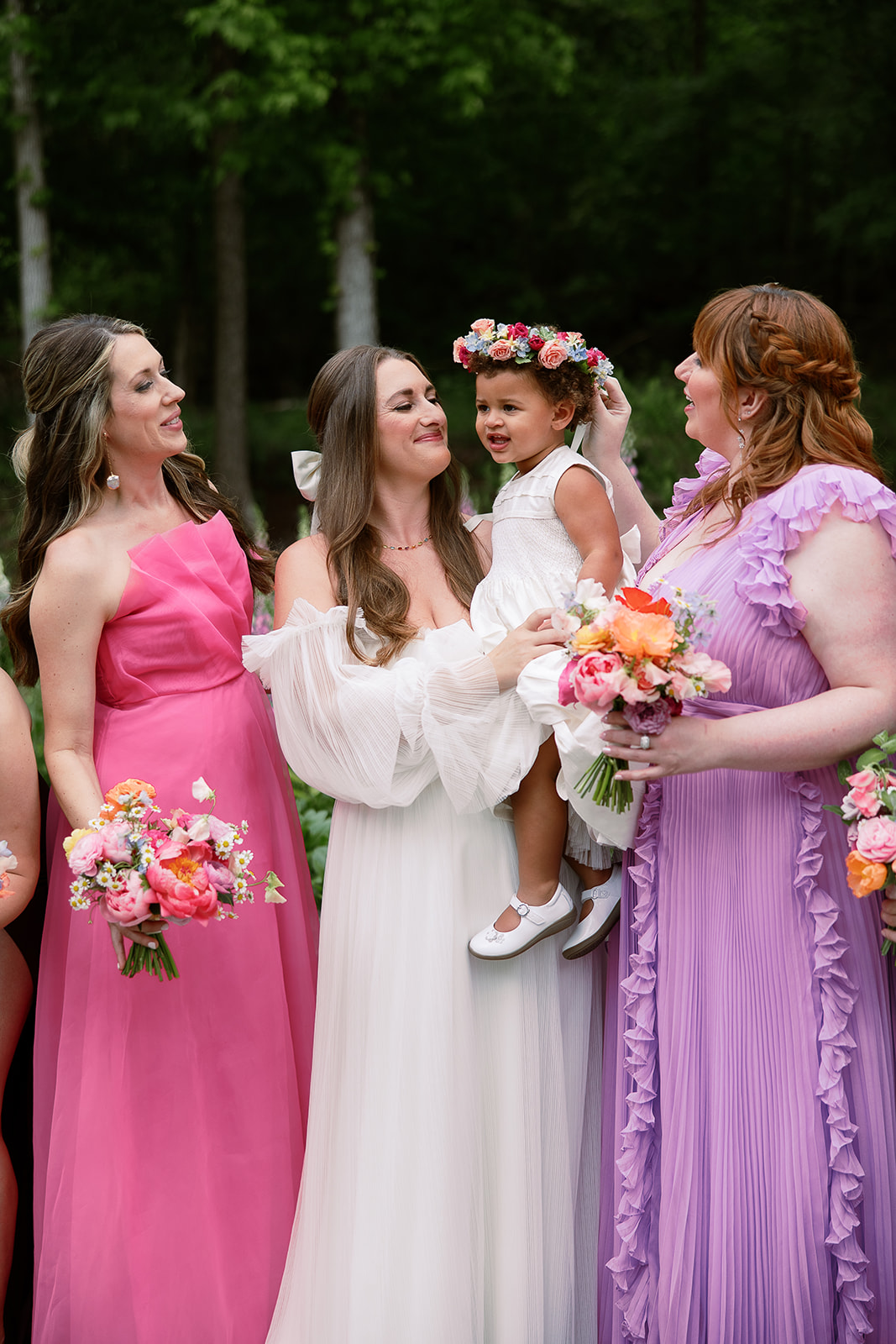 bride holds daughter in flower girl dress with bridesmaids around her. spring wedding in south carolina. Sarah Bradshaw Photography