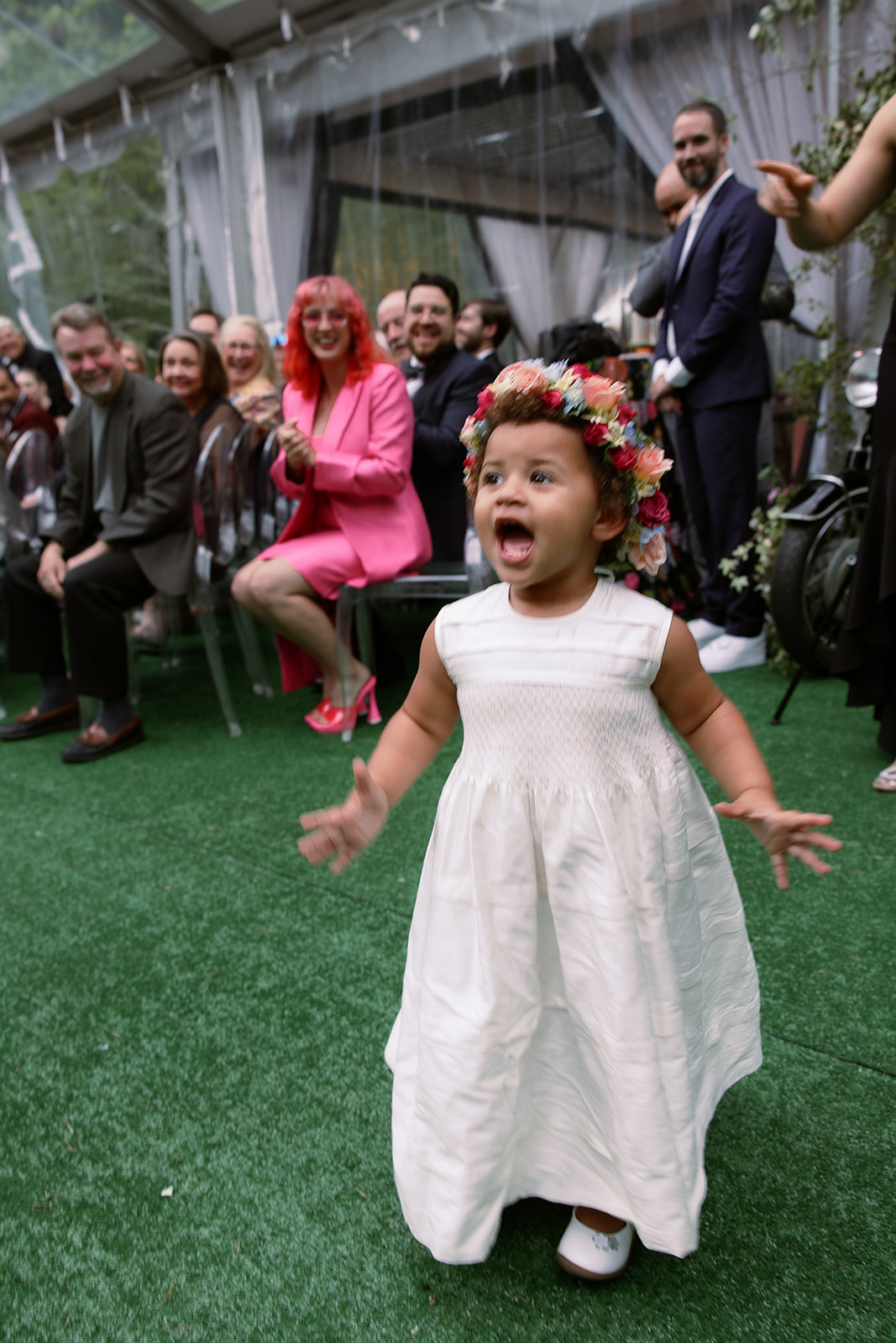 young flower girl in floral crown walks down aisle. at home tented wedding in south carolina. Sarah Bradshaw Photography