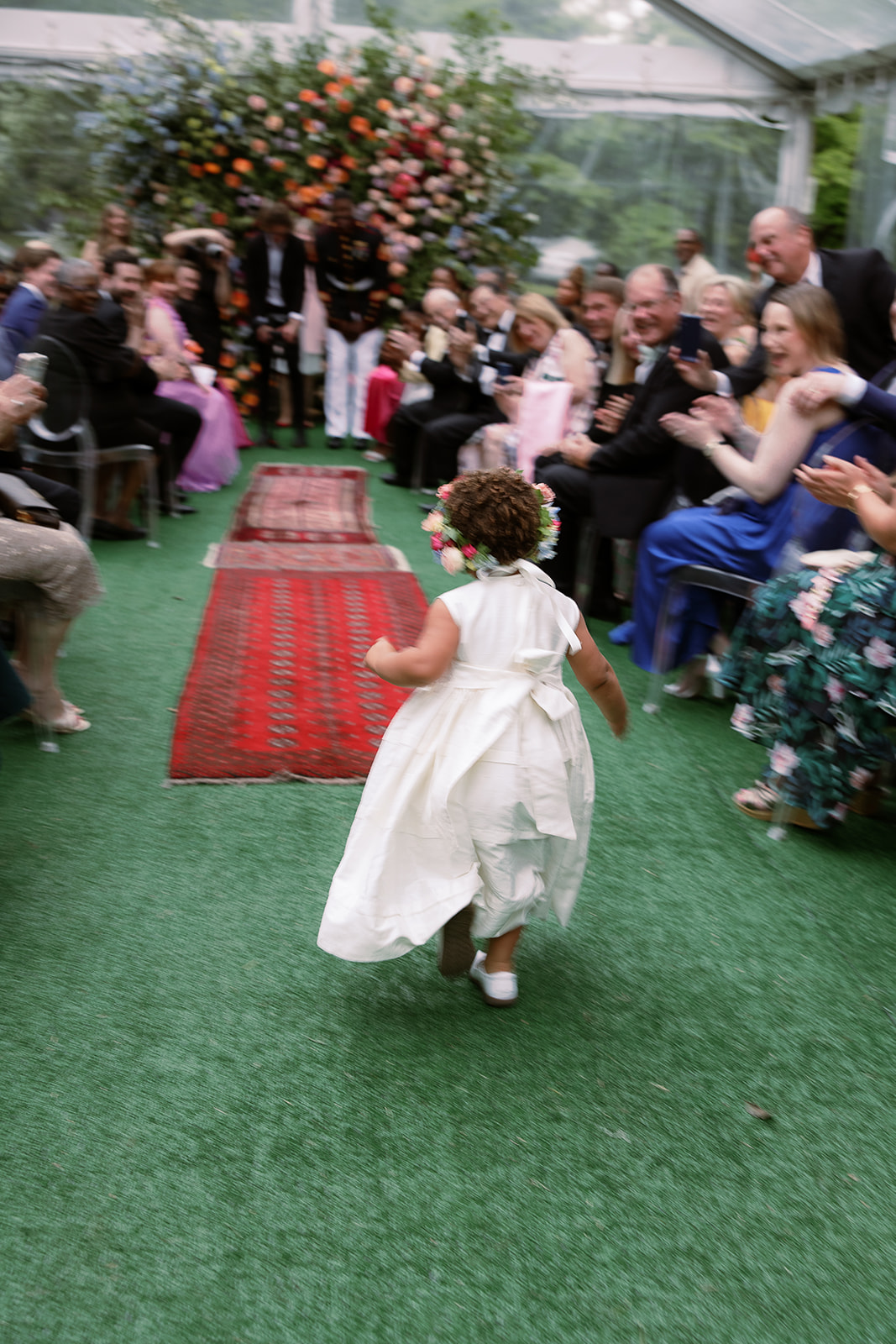 flower girl runs down wedding aisle to her dad, the groom. private home tented wedding in south carolina. Sarah Bradshaw Photography
