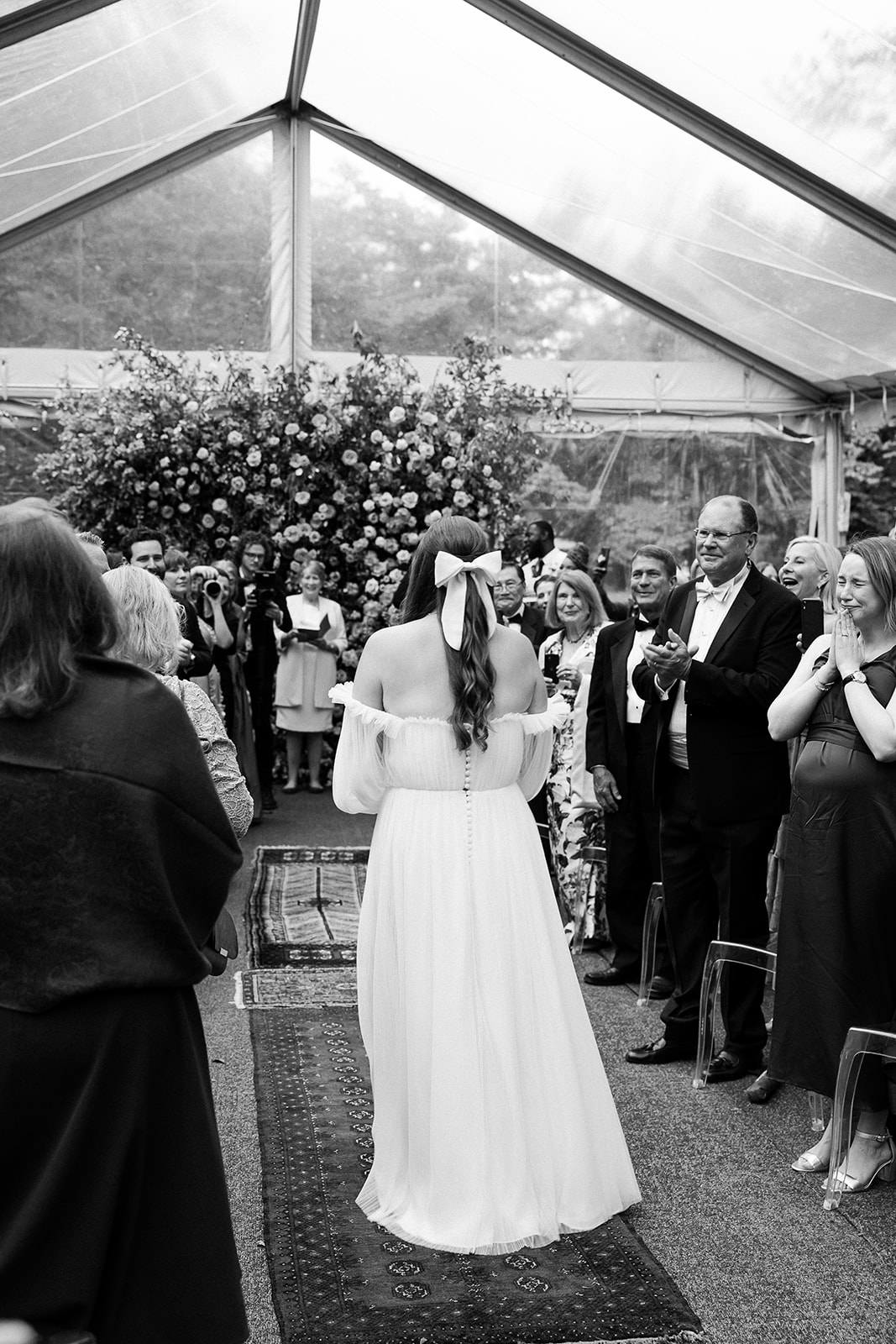 black and white photo of bride walking down ceremony aisle. private home tented wedding in south carolina. Sarah Bradshaw Photography