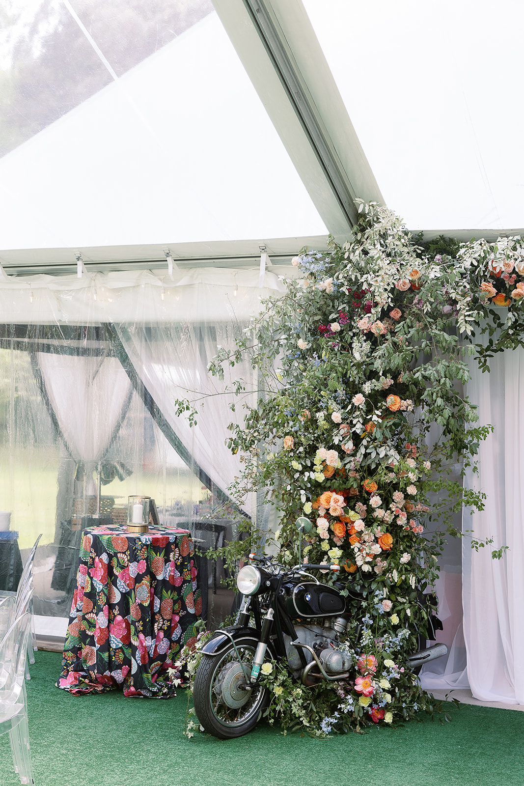 Colorful floral arch with motorcycle, entrance to wedding reception. Spring, private home tented wedding in south carolina. Sarah Bradshaw Photography