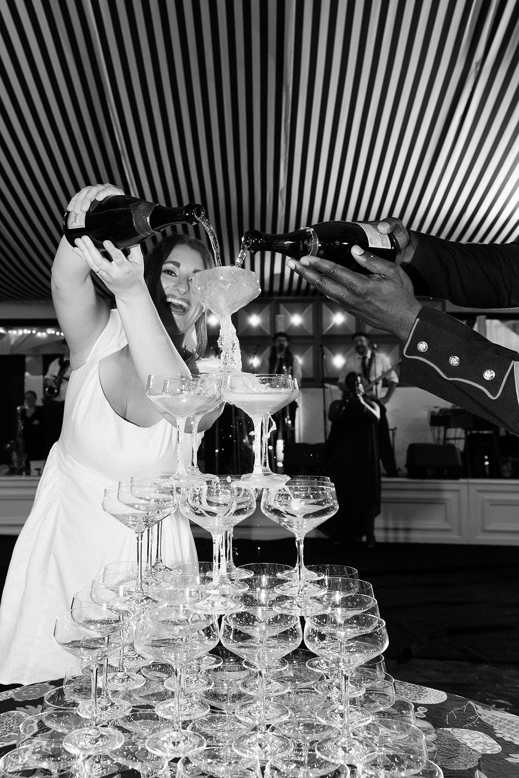 bride and groom filling champagne tower. Spring, private home tented wedding in south carolina. Sarah Bradshaw Photography
