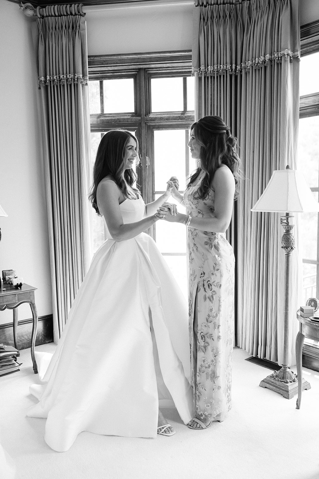 bride and bridesmaid celebrate on wedding morning. elegant spring wedding south carolina. sarah bradshaw photography