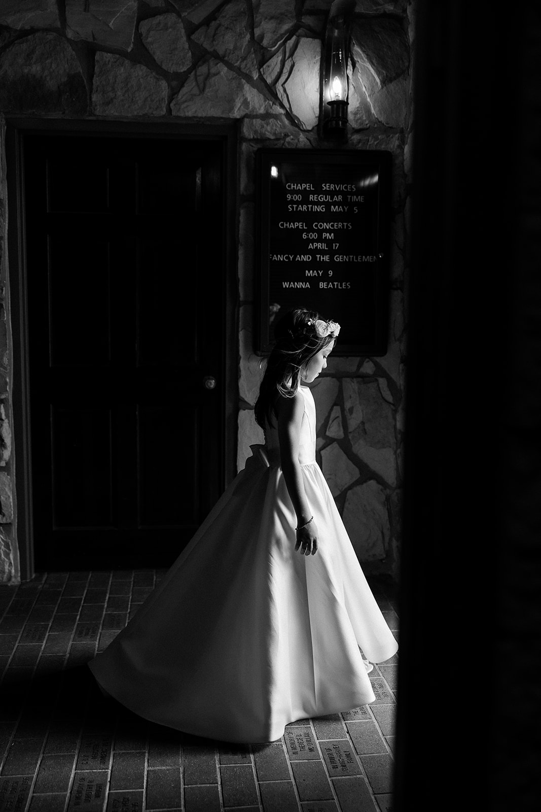 black and white portrait of flower girl walking in chapel. elegant south carolina spring wedding. sarah bradshaw photography