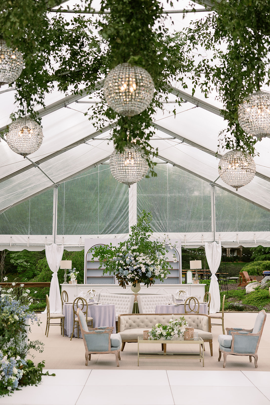 Hanging chandelier crsytal balls and greenery installation in tented wedding reception. elegant south carolina spring wedding. sarah bradshaw photography