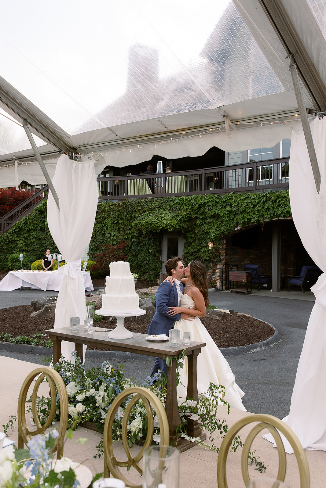 Bride and groom kiss in front of wedding cake. elegant south carolina spring wedding. sarah bradshaw photography