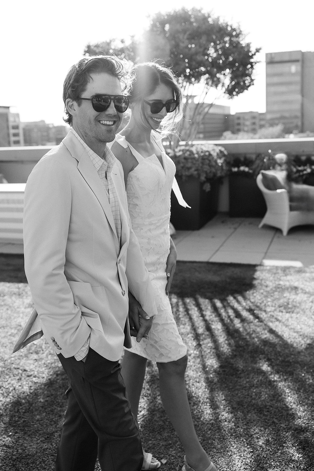 Candid portrait of bride and groom walking on rooftop terrace.  Italian inspired wedding rehearsal dinner in Greenville, SC. Sarah Bradshaw Photography