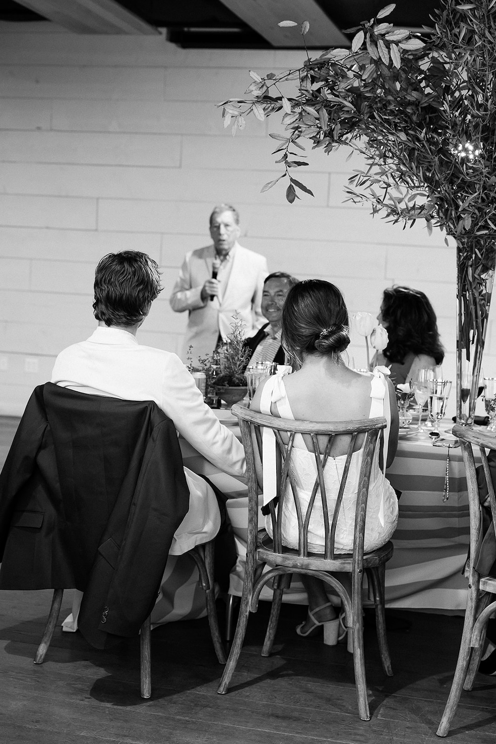 Bride and groom listen to rehearsal dinner speeches.  Italian inspired wedding rehearsal dinner in Greenville, SC. Sarah Bradshaw Photography