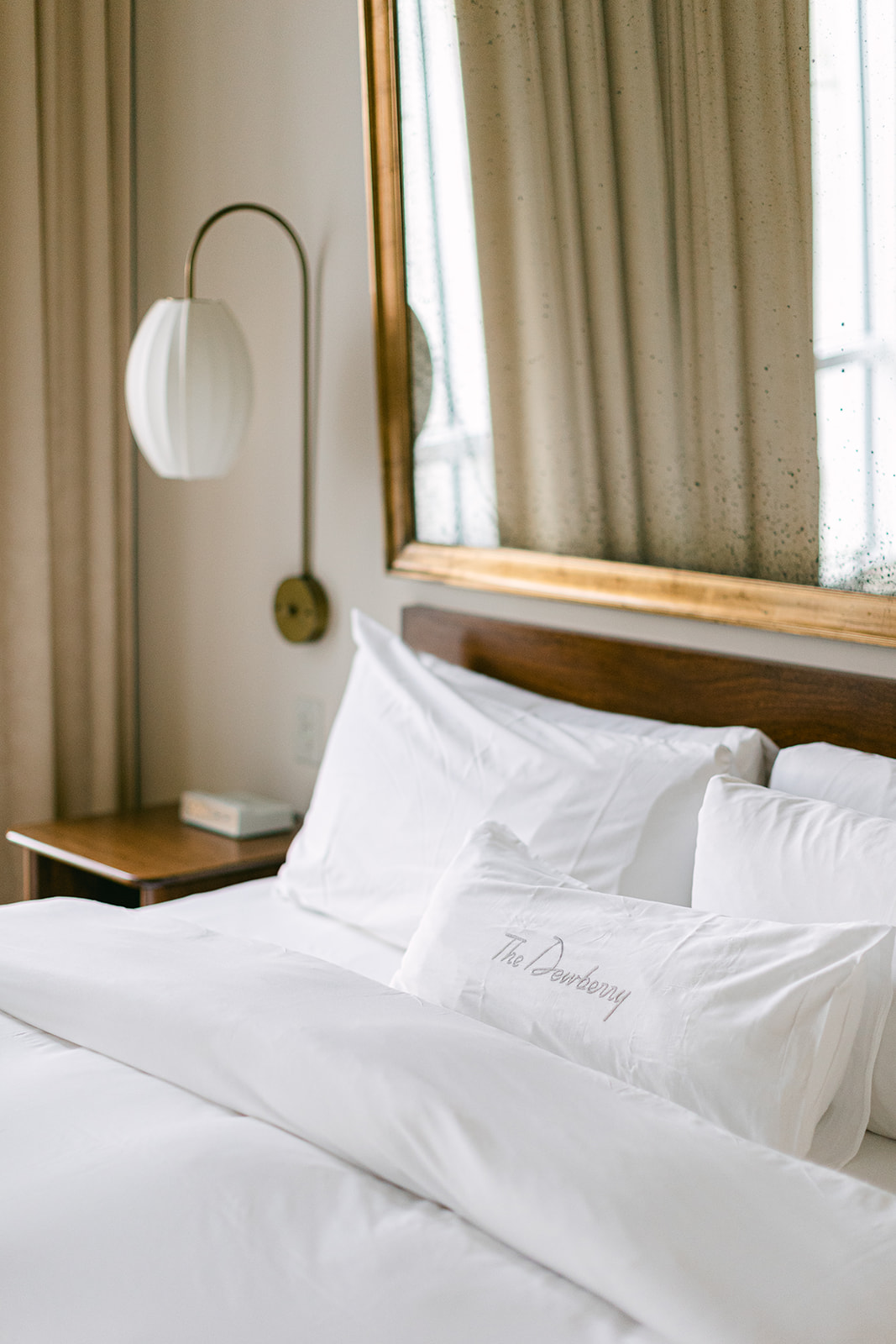 View of luxury hotel bedroom with embroidered pillows. The Dewberry Hotel, Charleston South Carolina. Sarah Bradshaw Photography