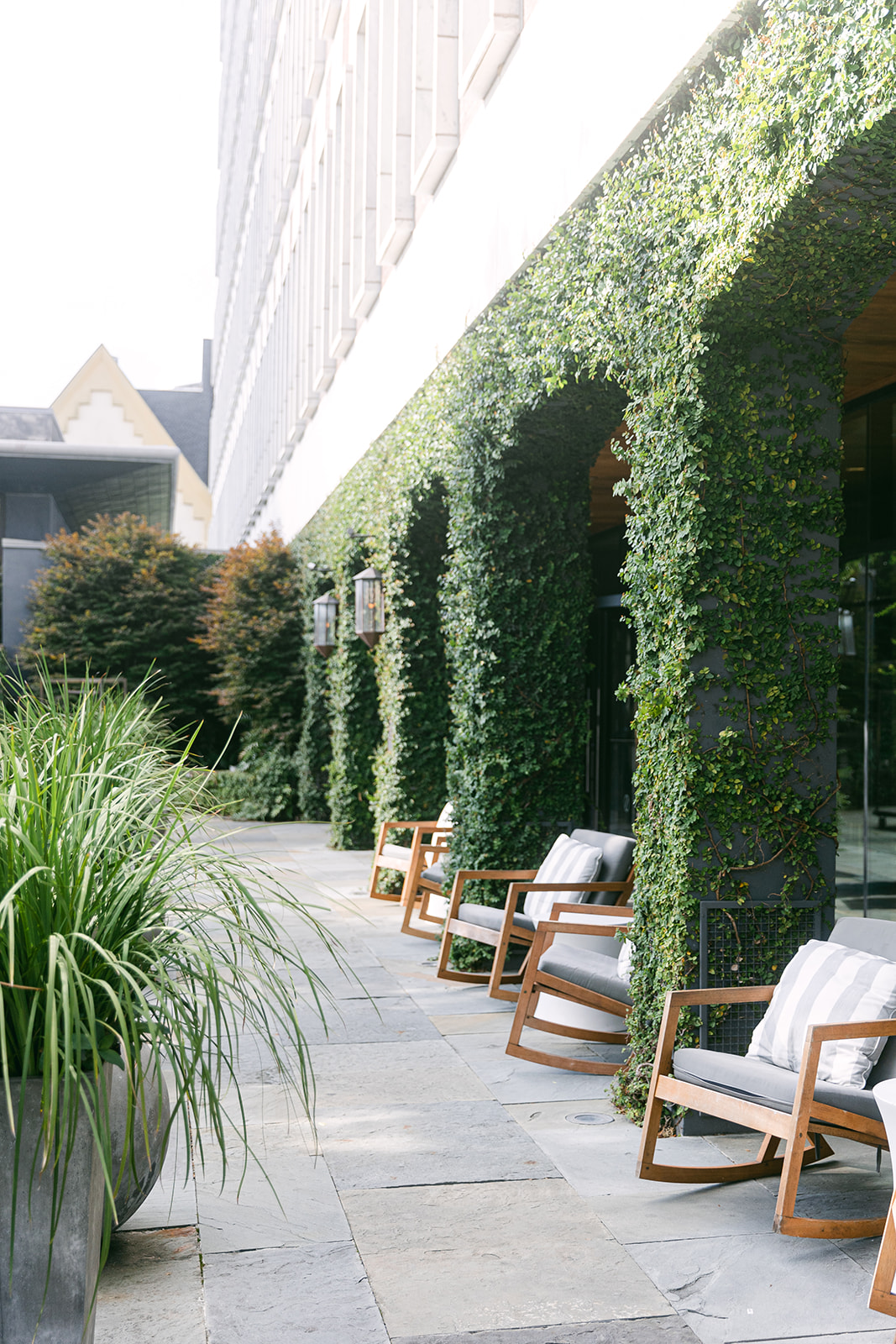 Rocking chairs nestled in ivy covered patio nooks. The Dewberry Hotel, Charleston South Carolina. Sarah Bradshaw Photography