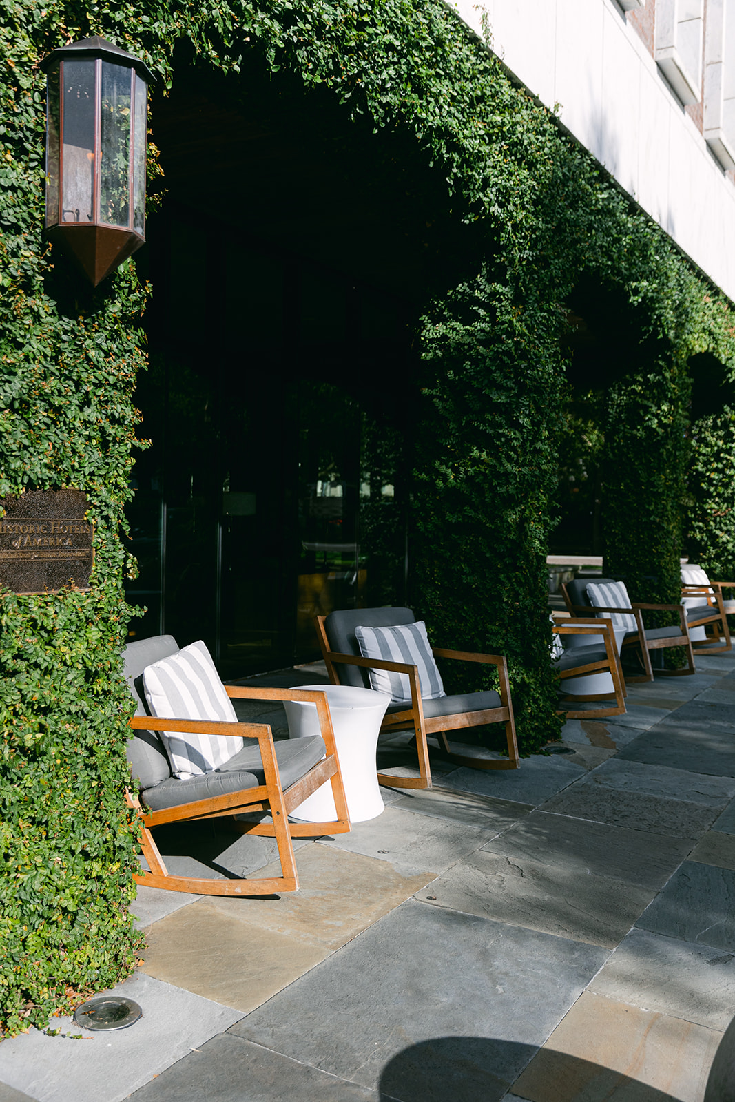 Rocking chairs in walled garden at luxury hotel. The Dewberry Hotel, Charleston South Carolina. Sarah Bradshaw Photography