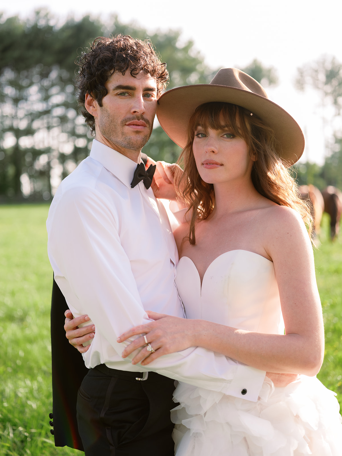 wedding portrait on farm. bride in strapless dress, hat. groom in tuxedo. chic equestrian wedding inspiration at Red Fox Inn, Middleburg Virginia. Sarah Bradshaw