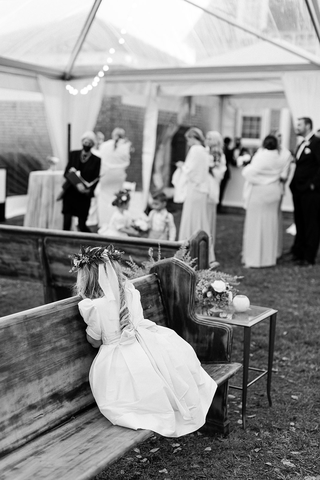 wedding guests gather around repurposed church pews in wedding tent. Classic timeless winter wedding, woodlawn manor, alexandria va. Sarah bradshaw photography