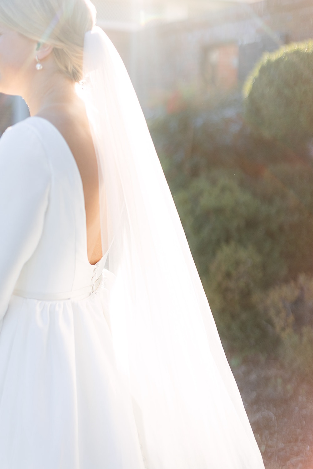 portrait of sunlight filtering through bride's long wedding veil. open back wedding dress. Classic timeless winter wedding, woodlawn manor, alexandria va. Sarah bradshaw photography