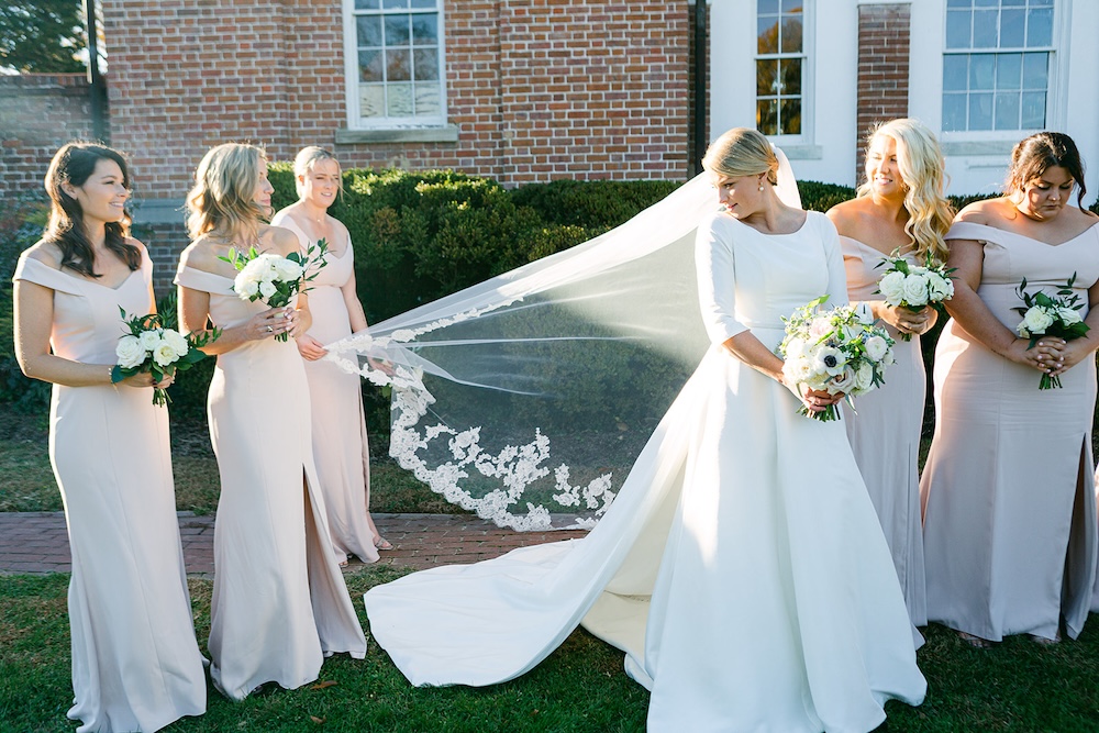 bridesmaids help bride with her lace trimmed wedding veil. Classic timeless winter wedding, woodlawn manor, alexandria va. Sarah bradshaw photography