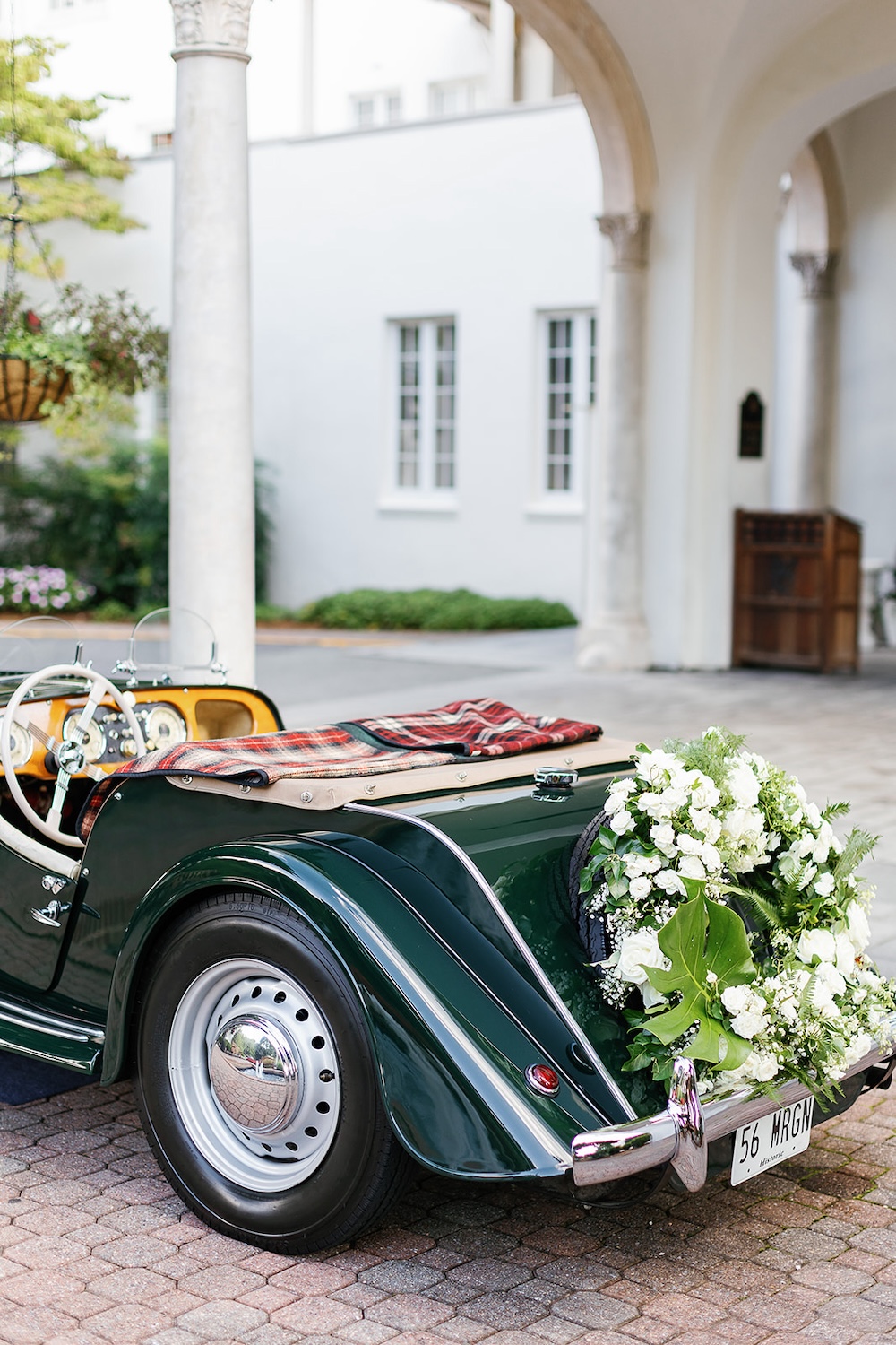 elegant floral wreath on back of vintage car, white roses, baby's breath, ferns, greenery. Modern Luxe Washington DC wedding, Sarah Bradshaw Photography