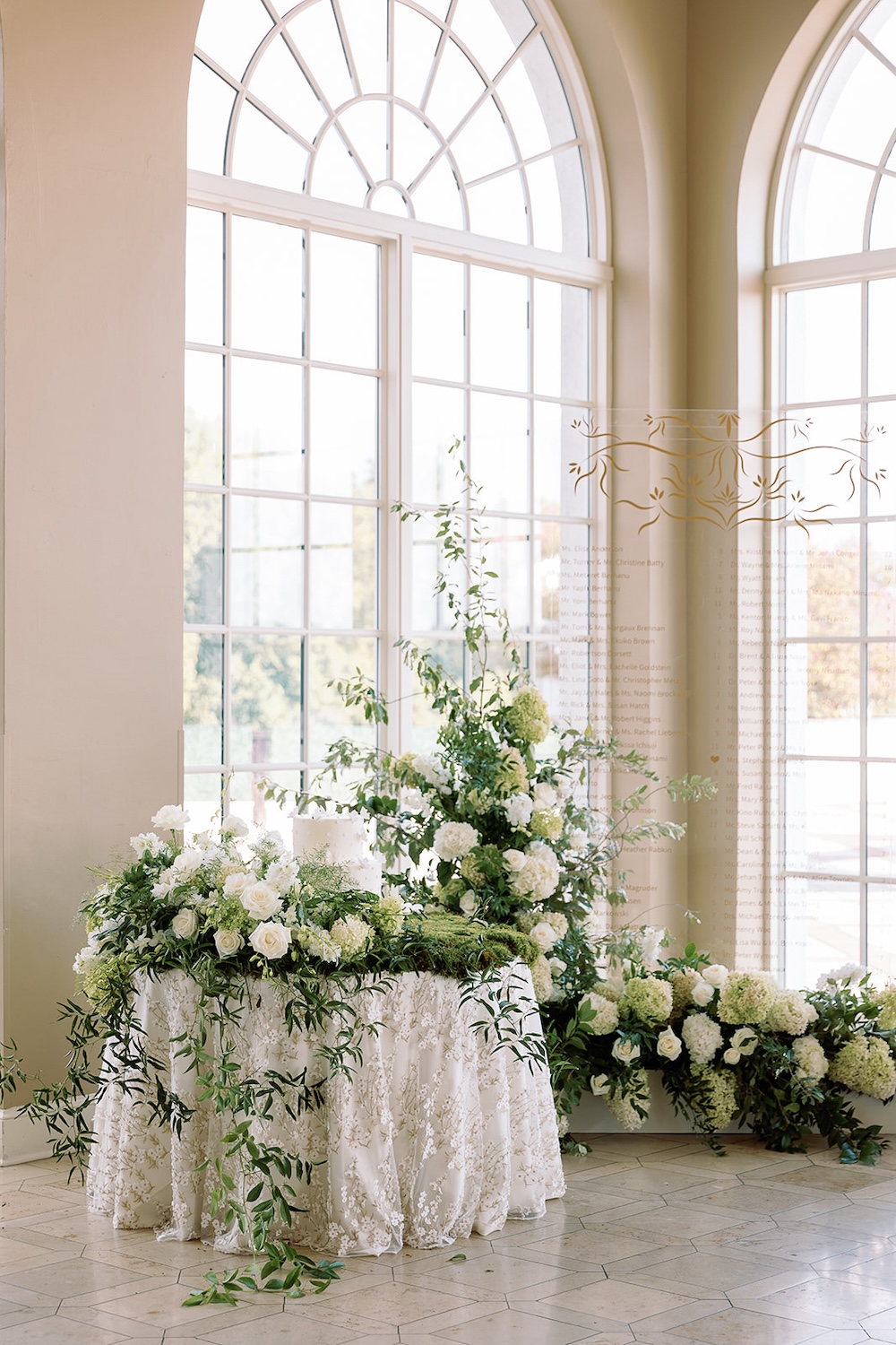 Lush floral installation, greenery, white roses, white hydrangeas. Acrylic wedding seating chart display, cake table. Modern Luxe Washington DC wedding, Sarah Bradshaw Photography
