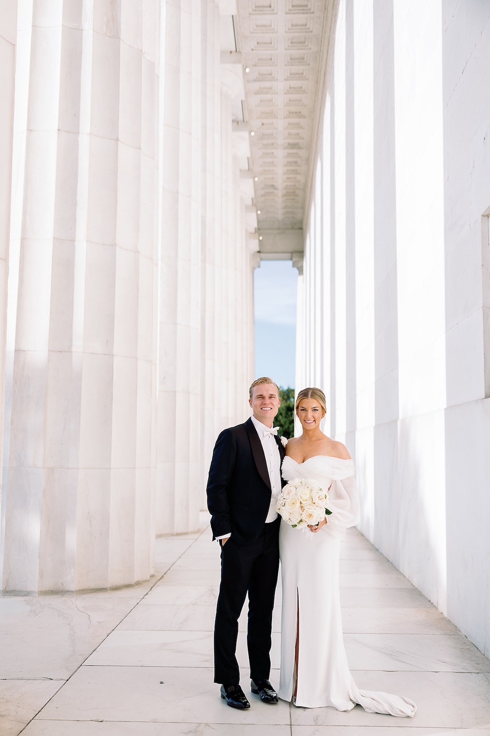 Wedding portrait of bride and groom next to columns at Lincoln Memorial. High end hotel ballroom wedding, The Fairmont, Washington DC. Sarah Bradshaw Photography