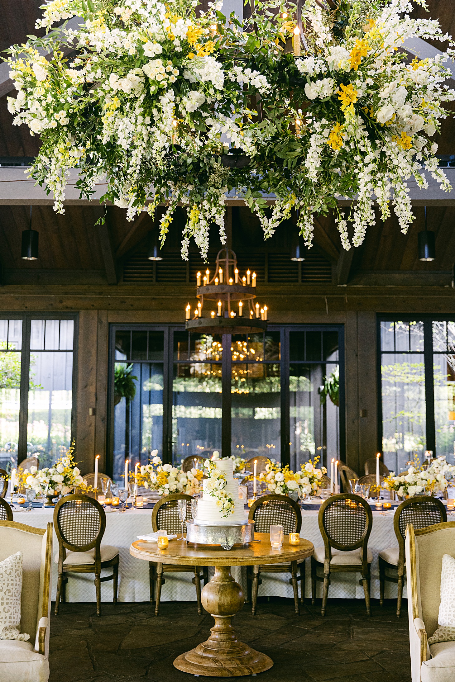 Soft white and yellow flowers ceiling installation over cake summer wedding at Old Edwards Inn by Sarah Bradshaw