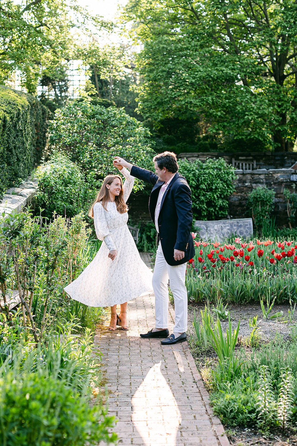Couple dancing in garden. Spring wedding engagement photo session. Sarah Bradshaw Photography.