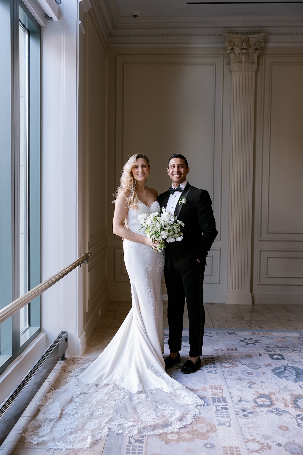 Formal portrait of bride and groom in front of large window. Modern Washington DC wedding at National Museum of Women in the Arts. Sarah Bradshaw Photography.