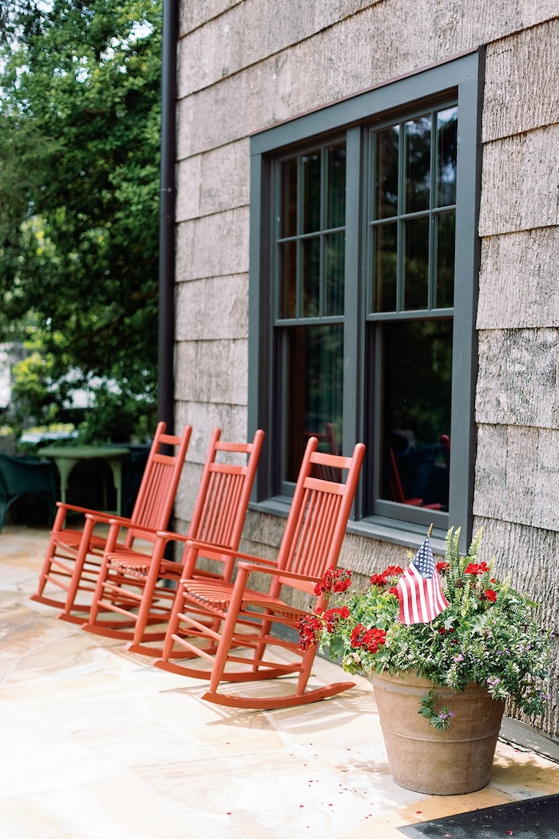 Red rocking chairs on sun porch at mountain lodge. High Hampton in North Carolina, Sarah Bradshaw Photography