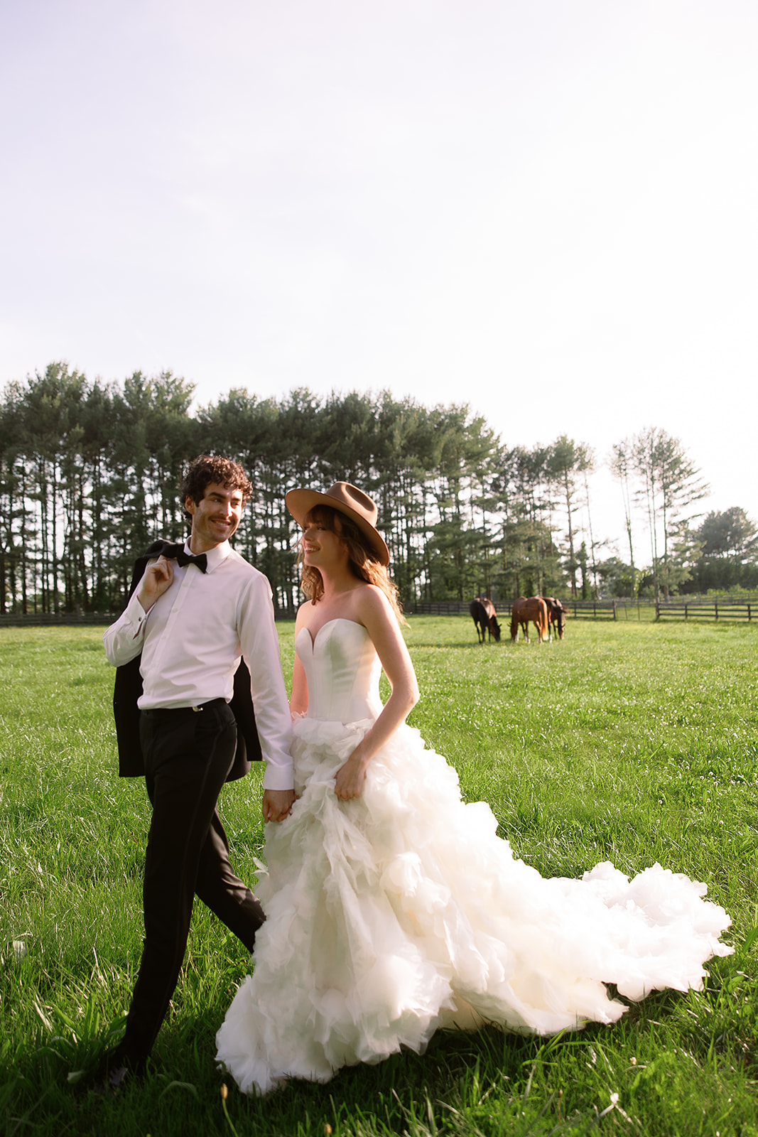 bride and groom portrait walking in horse field. chic farm wedding inspiration at Red Fox Inn, Middleburg Virginia. Sarah Bradshaw