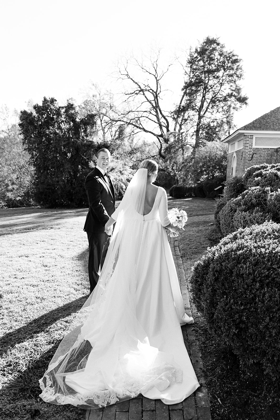 black and white portrait of bride and groom walking in garden. Classic timeless winter wedding, woodlawn manor, alexandria va. Sarah bradshaw photography