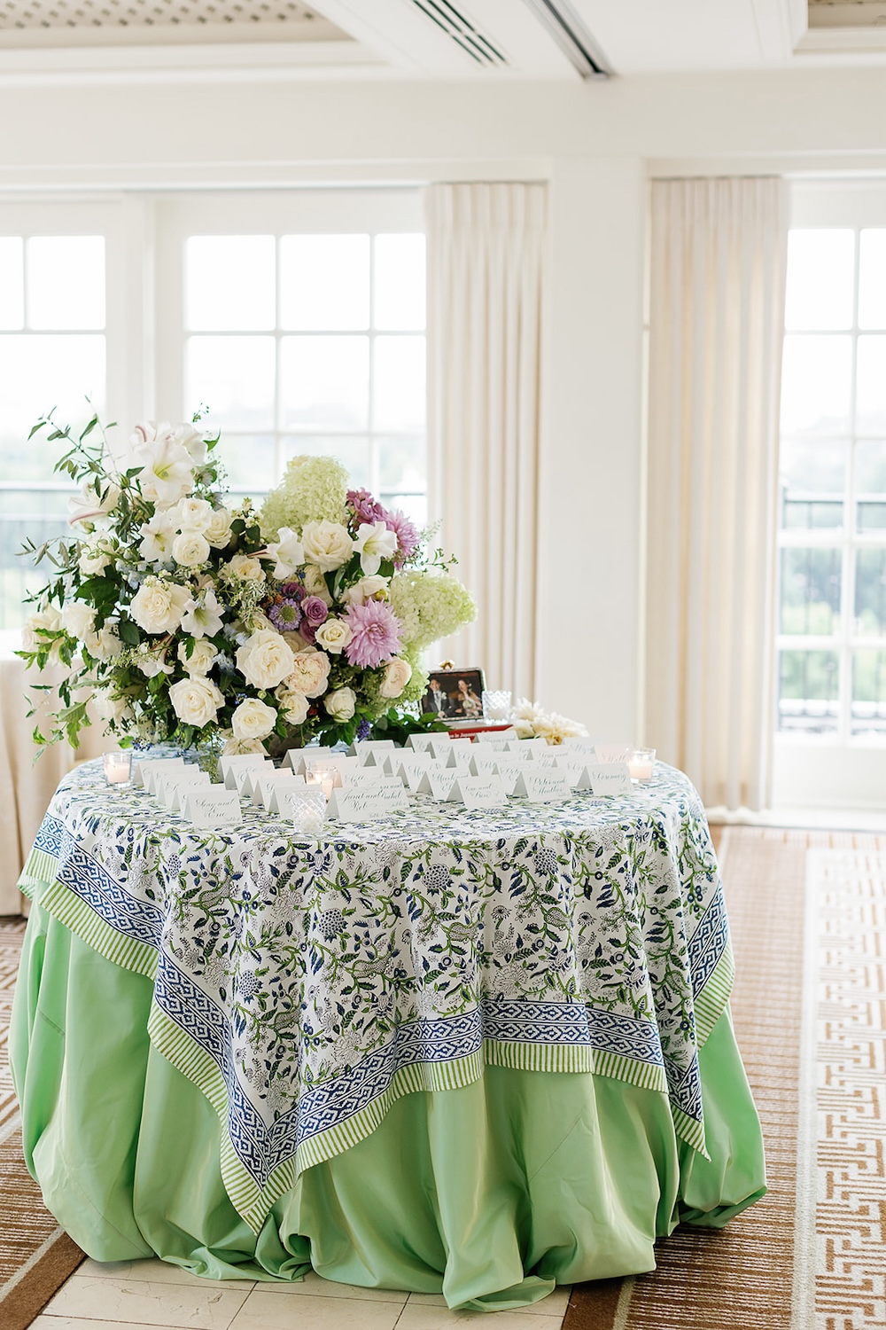 spring inspired escort card table display, bold patterned table linen. lush floral arrangement. calligraphy escort cards. Elegant rehearsal dinner at the Hay Adams Hotel, Washington DC. Sarah Bradshaw Photography